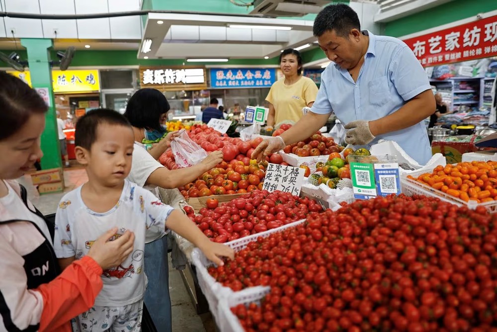 Khách hàng chọn cà chua tại một quầy hàng bên trong chợ buổi sáng ở Bắc Kinh, Trung Quốc