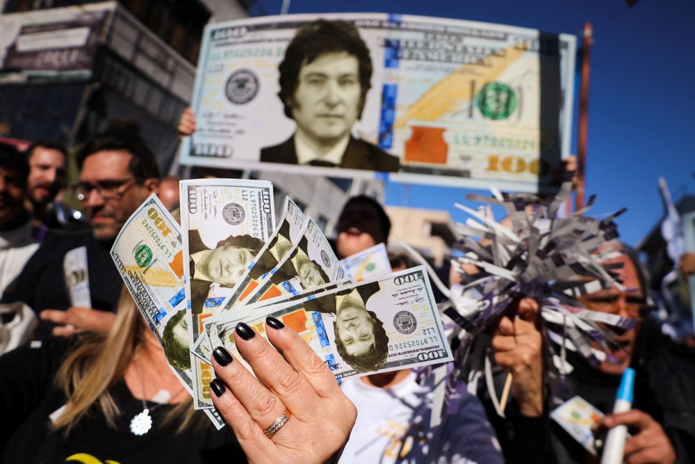 Những người ủng hộ ứng cử viên tổng thống Argentina Javier Milei cầm những tờ đô la có hình ông trong một cuộc vận động tranh cử
