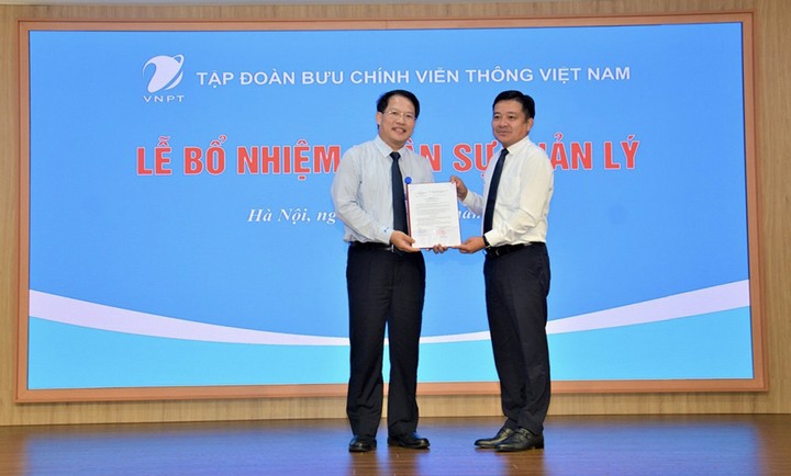 Ông Huỳnh Quang Liêm, Tổng giám đốc Tập đoàn VNPT trao quyết định bổ nhiệm cho ông Nguyễn Văn Tấn (bên trái)